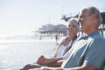 Seniorenpaar entspannt am sonnigen Strand — Stockfoto