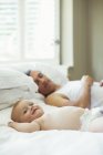 Padre y bebé relajándose en la cama - foto de stock