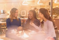 Women friends sharing dessert at cafe table — Stock Photo