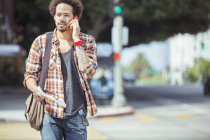 Hombre hablando por celular en paso de peatones urbano - foto de stock