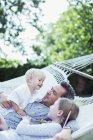 Padre e hijos relajándose en hamaca - foto de stock