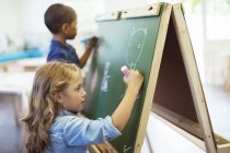 Students drawing on chalkboard in classroom — Stock Photo