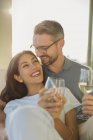 Couple affectueux souriant et buvant du vin blanc — Photo de stock