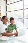 Grandfather and grandson using laptop — Stock Photo