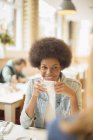 Jeunes femmes heureuses buvant du café dans le café — Photo de stock