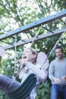 Father pushing daughter on swing outdoors — Stock Photo