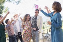 Family throwing confetti on newlywed couple — Stock Photo