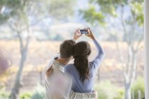 Casal tirando selfie com telefone da câmera no pátio — Fotografia de Stock