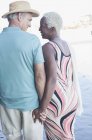 Seniorenpaar hält Händchen und geht am Strand spazieren — Stockfoto