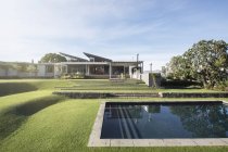 Modern swimming pool, yard and house — Stock Photo