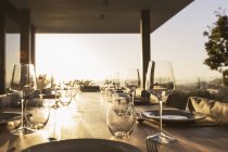 Vista panoramica di placesettings sul tavolo patio tramonto — Foto stock