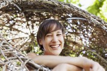 Mujer riendo en casa del árbol - foto de stock