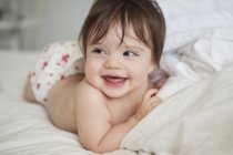 Bambino ragazza posa in lenzuola — Foto stock