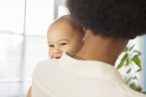 Mother carrying baby boy at home — Stock Photo