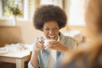 Счастливые молодые женщины пьют кофе в кафе — стоковое фото