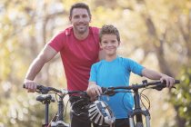 Портрет отца и сына езда на велосипеде — стоковое фото