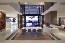 Maison de luxe moderne vitrine intérieure avec vue sur l'océan coucher de soleil — Photo de stock