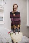 Ritratto donna sorridente che porta shopping bag in vicolo — Foto stock