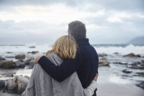 Coppia serena che si abbraccia sulla spiaggia invernale — Foto stock