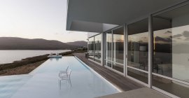 Maison de luxe moderne vitrine extérieure avec piscine à débordement et vue sur l'océan — Photo de stock