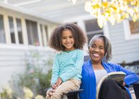 Portrait of happy grandmother and granddaughter on patio — Stock Photo