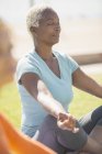 Serene woman meditating in lotus position outdoors — Stock Photo