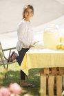 Portrait of smiling girl working lemonade stand — Stock Photo