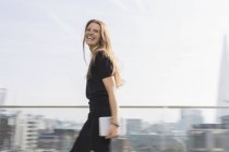 Retrato mujer de negocios riendo con tableta digital en balcón urbano - foto de stock