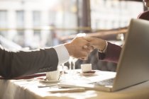 Cropped image of business people shaking hands in restaurant — Stock Photo