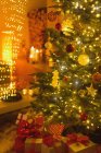 Gros plan de cadeaux sous l'arbre de Noël illuminé — Photo de stock