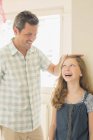 Father measuring daughter's height on wall — Stock Photo