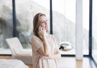 Жінка розмовляє на мобільному телефоні в сучасній вітальні — стокове фото