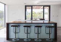 Einfache, moderne Wohnvitrine innen Kücheninsel mit Barhockern — Stockfoto