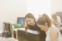Mujeres de negocios que se reúnen en la computadora en la oficina moderna - foto de stock