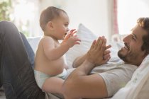 Padre giocare con bambino ragazzo su letto — Foto stock