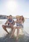 Family sitting in chairs in waves — Stock Photo