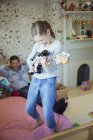 Девушка играет на гитаре для отца в спальне — стоковое фото