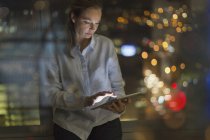 Empresária trabalhando até tarde no tablet digital no escritório à noite — Fotografia de Stock