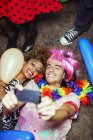 Couple taking self-portraits with smartphone on floor at party — Stock Photo