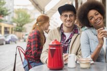 Couple drinking coffee at sidewalk cafe — Stock Photo