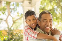 Portrait of smiling grandfather and grandson hugging outdoors — Stock Photo