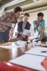 Kreative Geschäftsleute überprüfen Papierkram bei Besprechungen am Schreibtisch — Stockfoto