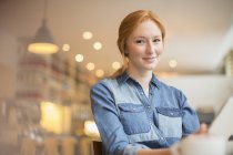 Happy young woman holding menu in cafe — Stock Photo