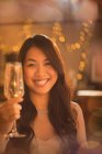 Портрет улыбающейся китаянки, пьющей шампанское на флейте — стоковое фото
