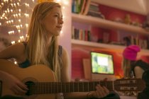 Teenager-Mädchen spielt Gitarre im Schlafzimmer — Stockfoto