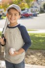 Портрет усміхненого хлопчика з бейсболом і кажаном — стокове фото