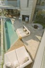 Terrasse de luxe moderne ensoleillée avec terrasses et piscine couverte — Photo de stock