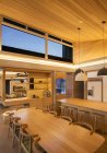 Illuminated wood ceiling over kitchen and dining table — Stock Photo