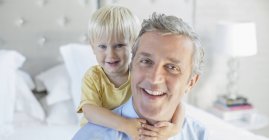 Father and son hugging on bed — Stock Photo