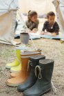 Ботинки выстроились в очередь снаружи палатки в кемпинге — стоковое фото